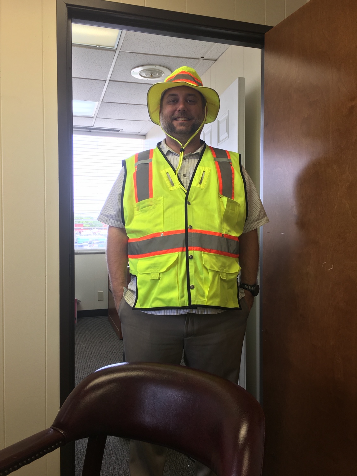 Steven R. Beck wearing high-visibility safety gear in an office doorway